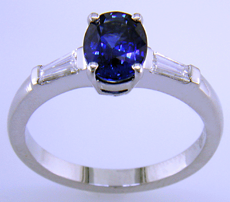 Side view of oval Sapphire set with tapered baguette diamonds in a hand-crafted platinum ring.