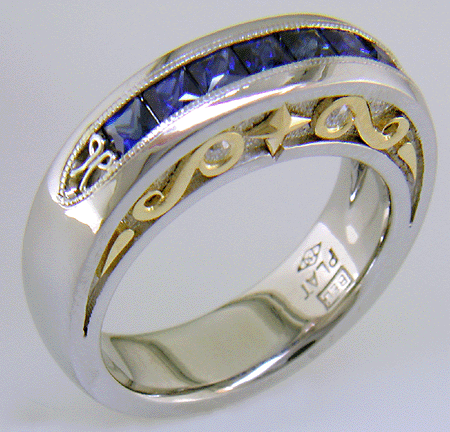 Seven Princess-cut Sapphires set in a platinum ring with diamonds and 18kt gold accents.