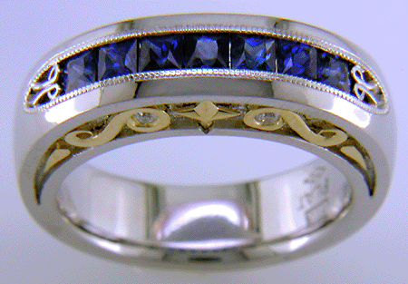 Seven Princess-cut Sapphires set in a platinum ring with diamonds and 18kt gold accents.