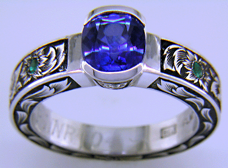 A cushion-cut Sapphire set in a beautifully hand crafted and engraved platinum ring.