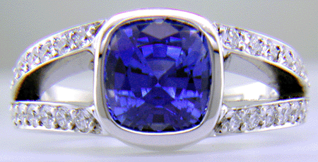 A cushion-cut sapphire set with diamonds in a custom platinum ring.