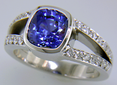 A cushion-cut sapphire set with diamonds in a custom platinum ring.