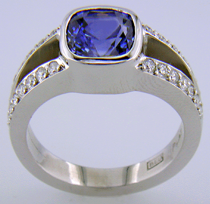Side view of a cushion-cut sapphire set with diamonds in a custom platinum ring.