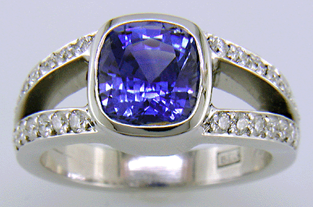 A cushion-cut sapphire set with diamonds in a custom platinum ring.