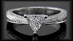Trilliant diamond engagement ring crafted of hand-engraved platinum.