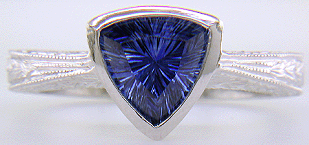 Concaved-facetted trillium Sapphire set in a hand-crafted, hand-engraved platinum ring. (J8707)