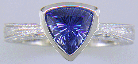 Concaved-facetted trillium Sapphire set in a hand-crafted, hand-engraved platinum ring. (J8707)