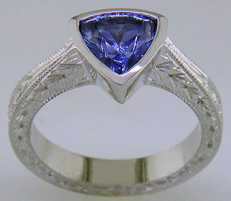 Concaved-facetted trillium Sapphire set in a hand-crafted, hand-engraved platinum ring. (J8707)
