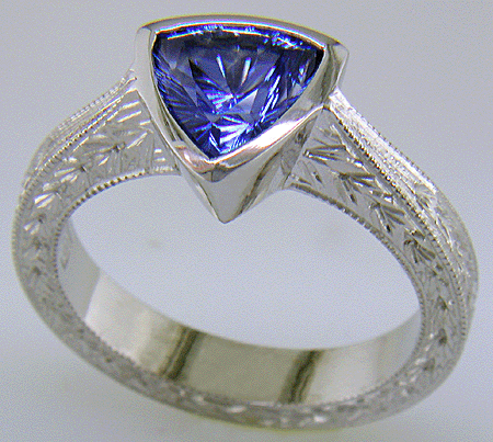 Concaved-facetted trillium Sapphire set in a hand-crafted, hand-engraved platinum ring. (J8707)