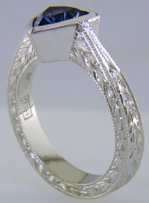 Concaved-facetted trillium Sapphire set in a hand-crafted, hand-engraved platinum ring. (J8707)