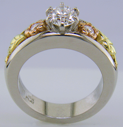 Custom platinum engagement ring with rose and green gold accents.