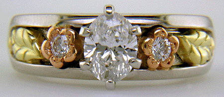 Custom platinum engagement ring with rose and green gold accents.