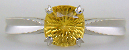 Concave faceted yellow sapphire set with two hidden diamonds in a hand-crafted platinum ring.