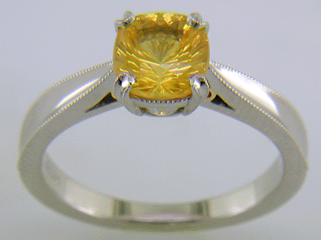 Concave faceted yellow sapphire set with two hidden diamonds in a hand-crafted platinum ring.