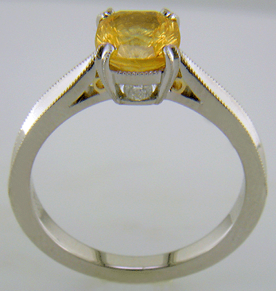 Side view of concave faceted yellow sapphire set with two hidden diamonds in a hand-crafted platinum ring.