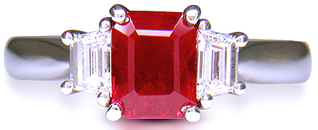 A fiery red ruby set with two trapezoid-cut diamonds in a handcrafted platinum ring. (J6405)