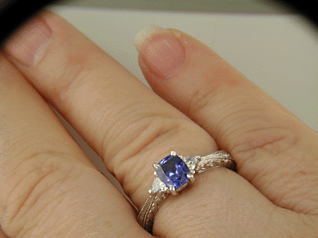 Cushion-cut sapphire and trilliant diamond hand-engraved platinum ring.