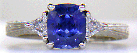 Cushion-cut sapphire and trilliant diamond hand-engraved platinum ring.