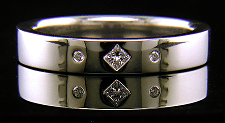 Platinum wedding band with burnish set diamonds.