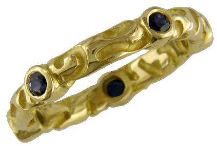 Richly carved 18kt gold band with five sparkling sapphires.