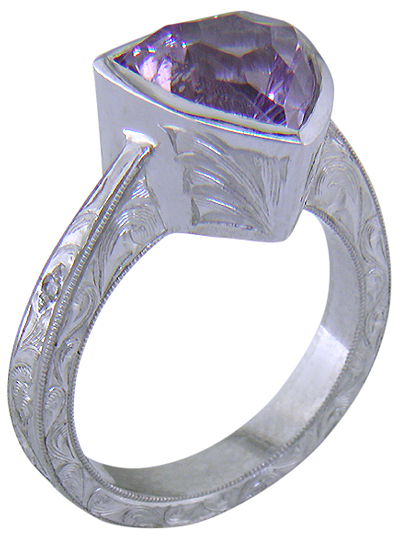 Concave-faceted Amethyst set in an engraved platinum ring. (J7415)