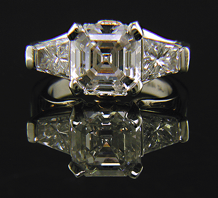 An Asscher-cut diamond set with two trapezoid-cut diamonds in a custom platinum ring.