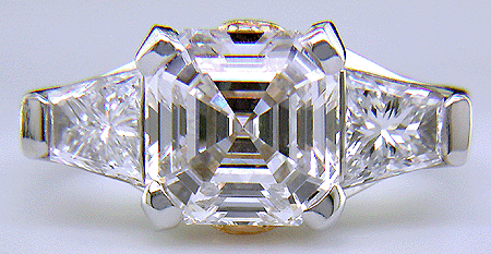 An Asscher-cut diamond set with two trapezoid-cut diamonds in a custom platinum ring.