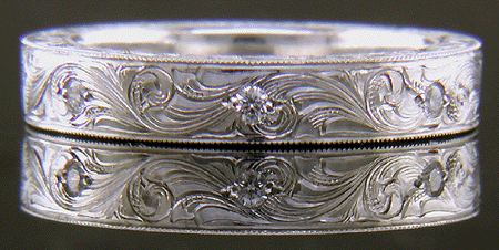 Hand engraved platinum band set with diamonds.