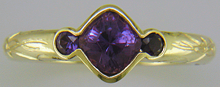 Cushion-cut Purple Sapphire with round Purple Sapphires in a custom platinum ring. (J8546)