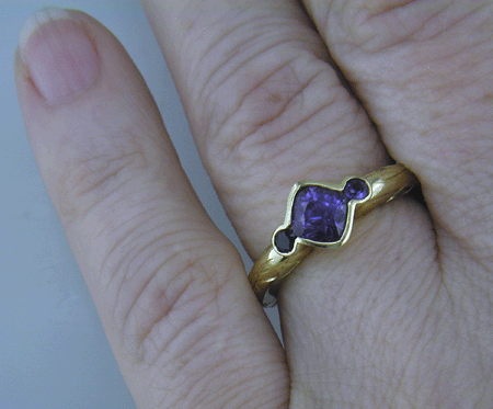 Cushion-cut Purple Sapphire with round Purple Sapphires in a custom platinum ring. (J8546)