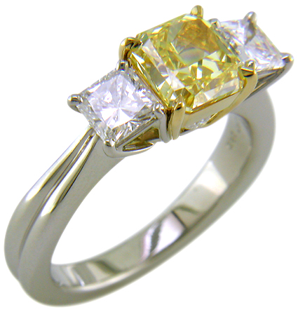 Fancy Intense Yellow diamond set with two radiant-cut diamonds in a custom platinum ring.