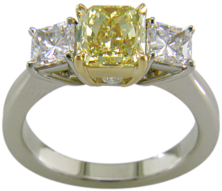 Fancy Intense Yellow diamond set with two radiant-cut diamonds in a custom platinum ring.