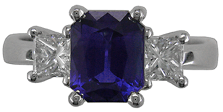 Radiant-cut sapphire ring with two princess-cut diamonds.