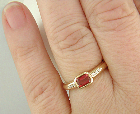 Emerald-cut Red Spinel set with round brilliant-cut diamonds in a handcrafted ring. (J6776)