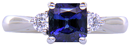 Emerald-cut sapphire set with two round diamonds in a handcrafted platinum ring. (J8540)