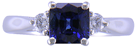 Emerald-cut sapphire set with two round diamonds in a handcrafted platinum ring. (J8540)