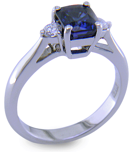 Emerald-cut sapphire set with two round diamonds in a handcrafted platinum ring. (J8540)