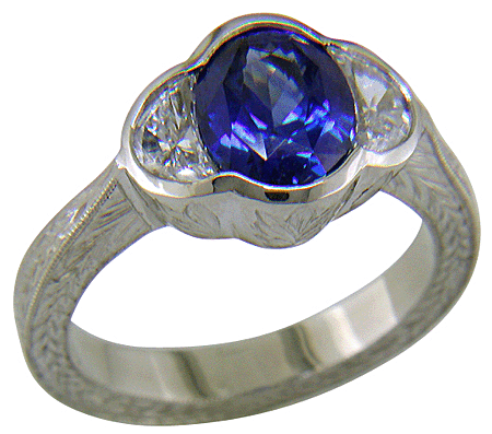 Oval sapphire set with crescent moon diamonds in an engraved platinum ring. (J7269)