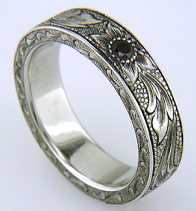 Hand engraved platinum band set with pyrope garnets.