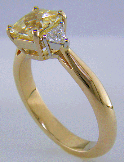 Yellow sapphire set with two trilliant diamonds in a handcrafted 18kt gold and platinum ring.