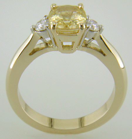 Side view of cushion-cut Yellow Sapphire set with two brilliant-cut diamonds in a handcrafted 18kt gold and platinum ring.