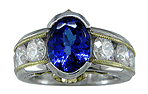 Oval tanzanite set with 6 brilliant diamonds in a custom platinum and gold ring.