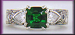 A cushion-cut Tsavorite garnet set in a beautifully hand crafted and engraved platinum ring.
